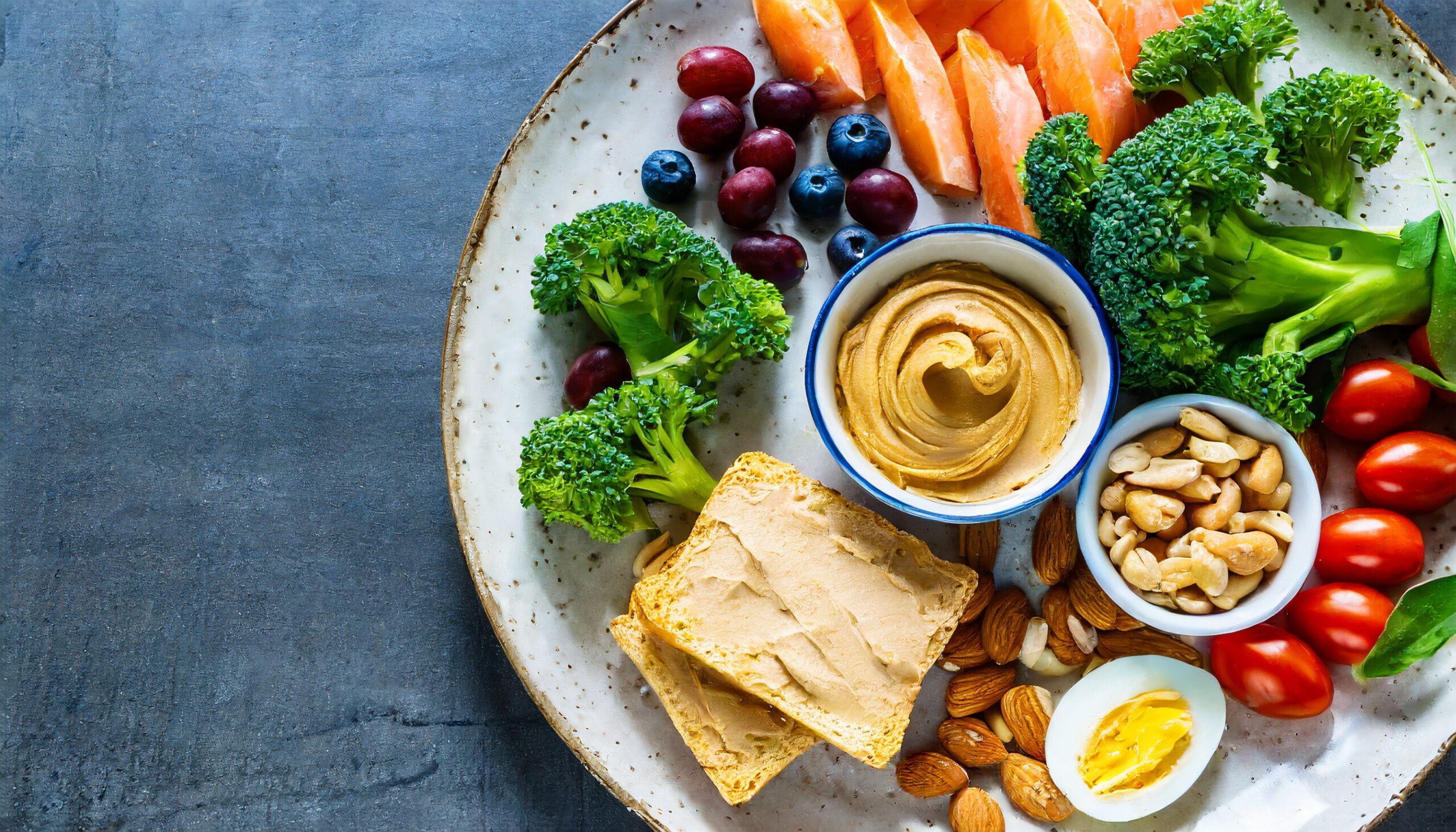 Plato saludable con mantequilla de frutos secos, frutas y verduras